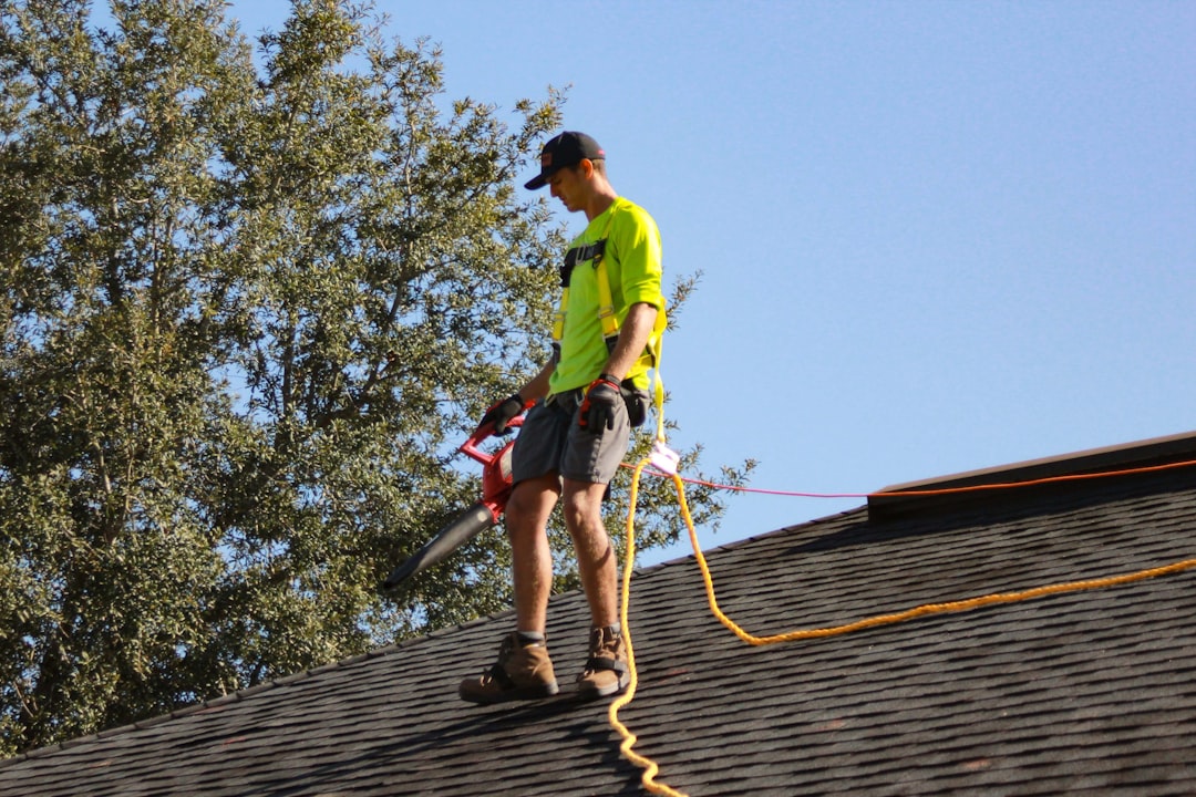 a-man-in-a-yellow-shirt-with-a-chainsaw-on-a-roof-q2iyhjrmtxu